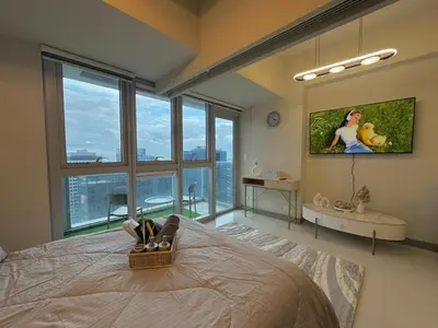 a bedroom with a large bed with a large window at 35th Prime Staycation BGC in Manila