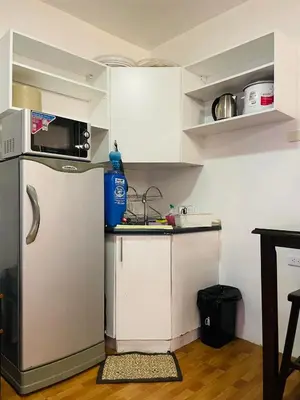 a small kitchen with a refrigerator and a microwave at Cozy Transient Home Uno in Manila
