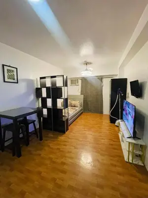 a living room with a table and a room with a bed at Cozy Transient Home Uno in Manila