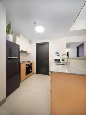 a kitchen with black appliances and a black door at Modern 2-Bedroom BGC Condo by Uptown Mall in Manila