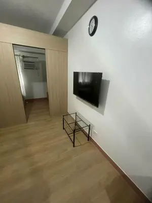 a room with a wall with a tv on a wall at Staycation by Carmen Romualdo in Manila