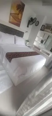 a bedroom with a large white bed with white sheets at Manila bay view condo birch tower in Manila