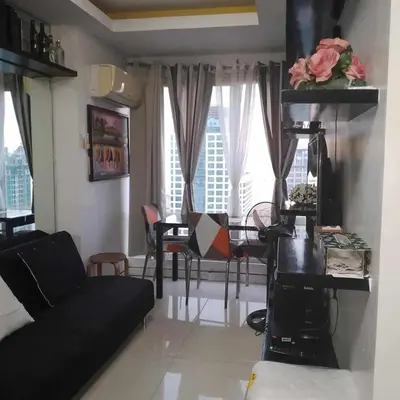 a living room with a black couch and a table at Manila bay view condo birch tower in Manila