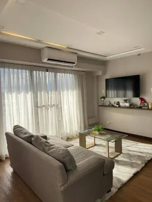 a living room with a couch and a table at Exquisite Property Stays at Acacia Estate Taguig City in Manila