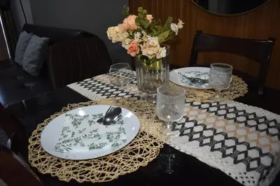 a table with two plates and a vase of flowers at The Cube at 15th in Taytay