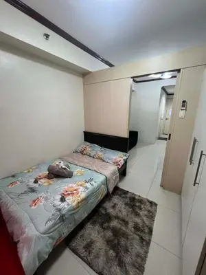 a small bedroom with a bed and a rug at Melas Condotel in Manila