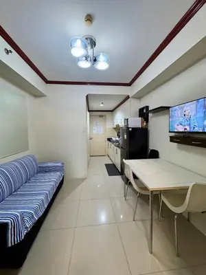 a room with a couch and a table and a tv at Melas Condotel in Manila