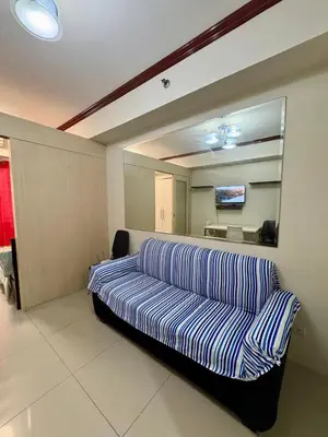 a living room with a couch and a mirror at Melas Condotel in Manila