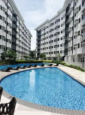 a large swimming pool in front of two large buildings at R and K staycation in Manila