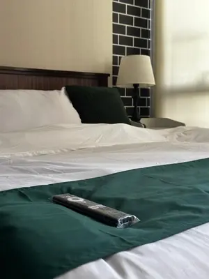 a remote control sitting on top of a bed at Reset at the Gramercy in Manila