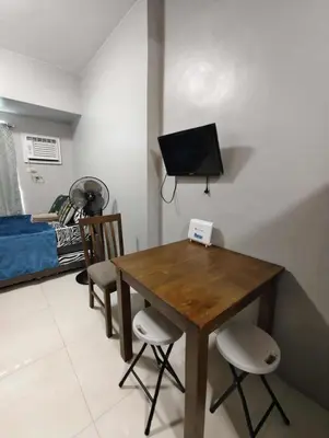 a dining room with a table and chairs and a tv at Staycation by Carlo and Chel's in Manila