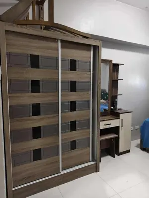 a room with a wooden closet with a desk at Staycation by Carlo and Chel's in Manila
