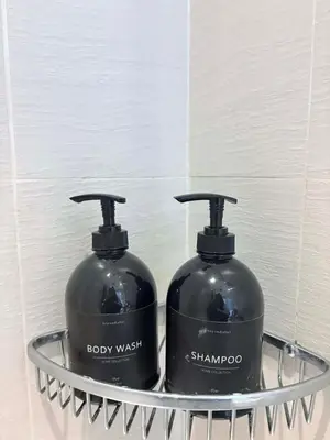 two black bottles of soap in a metal basket at 1 bedroom at Azure Urban Resort Condo in Manila