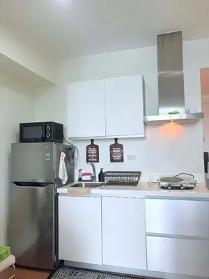 a kitchen with white cabinets and a refrigerator at 1 bedroom at Azure Urban Resort Condo in Manila