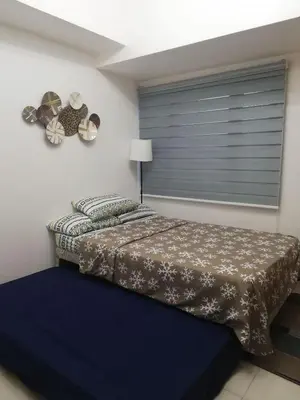 a bedroom with a bed and a window at Cozy Condo Near US Embassy in Manila in Manila