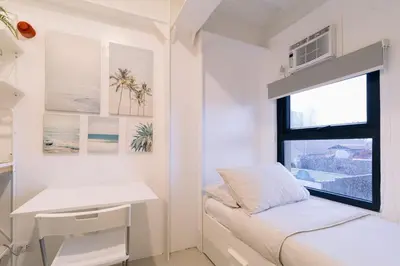 a small bedroom with a bed and a window at Canopy Agutaya BGC in Manila