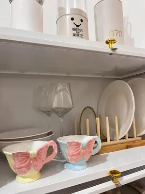 a shelf with two bowls and plates and a wine glass at Sweetluxx - SMDC Green 2 Residences Staycation in Dasmariñas