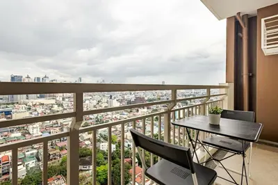 a balcony with a table and chairs overlooking a city at Stylish Condo - Cozy Urban Living in Manila