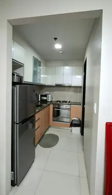 a kitchen with a stainless steel refrigerator and cabinets at Cozy Modern 2 Bedroom 81 Newport Boulevard in Manila