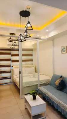 a room with a bed and a bed and a room with a bed sqor at Josh place Shell residence MOA in Manila