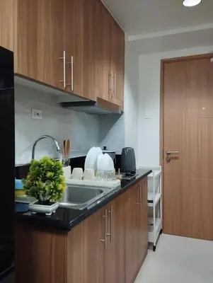 a kitchen with wooden cabinets and a sink at Wowstaycation in Manila