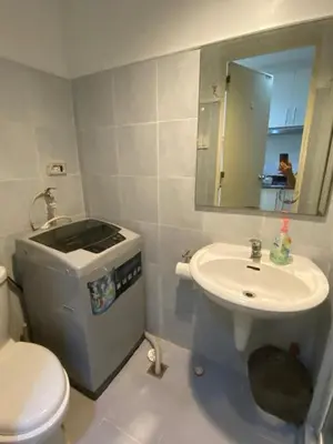 a bathroom with a sink and a toilet and a mirror at Moa Staycaion Stern Homes in Manila