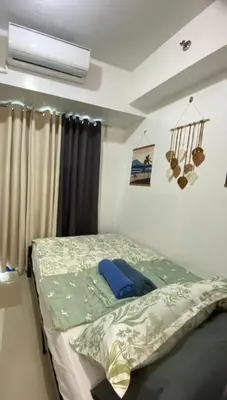 a bedroom with a bed and a air conditioner at Moa Staycaion Stern Homes in Manila