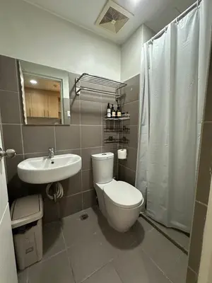 a bathroom with a toilet and a sink and a shower at Prime Salcedo Square Studio 2 Beds in Manila