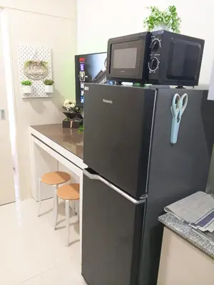 a black refrigerator with a microwave on top of it at Haute Haven - 1br with Balcony in Manila