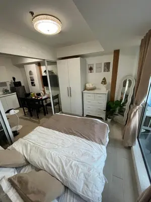 a bedroom with a bed and a dining room at Cozy Corner By R&K in Manila