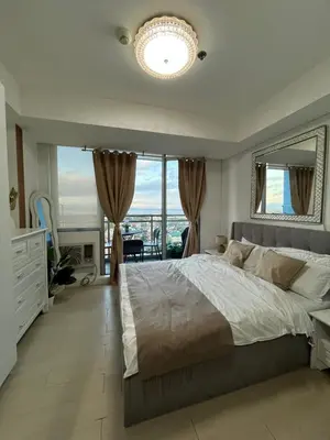 a bedroom with a large bed and a large window at Cozy Corner By R&K in Manila