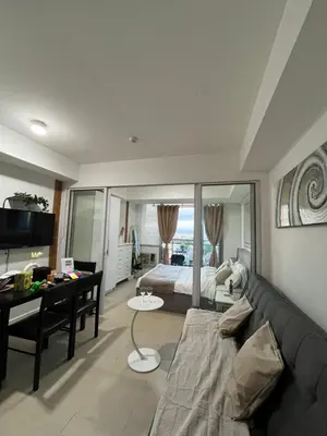 a living room with a couch and a bed at Cozy Corner By R&K in Manila