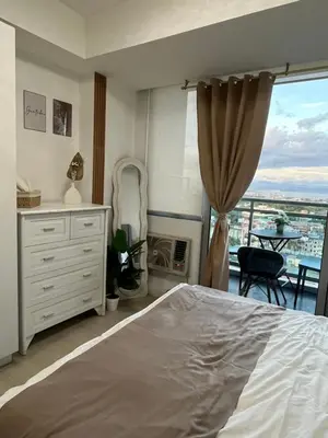 a bedroom with a bed and a balcony at Cozy Corner By R&K in Manila