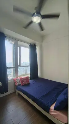 a bedroom with a blue bed and a ceiling fan at 2 Bedroom MEZZA RESIDENCES in Manila