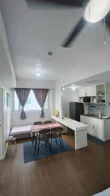 a living room with a table and chairs and a kitchen at 2 Bedroom MEZZA RESIDENCES in Manila