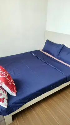 a bed with blue sheets and red pillows on it at 2 Bedroom MEZZA RESIDENCES in Manila