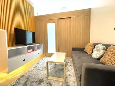 a living room with a couch and a tv at Direct Pool Access in Shore Residences near SM MOA in Manila