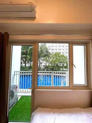 a bedroom with a window with a view of a balcony at Direct Pool Access in Shore Residences near SM MOA in Manila