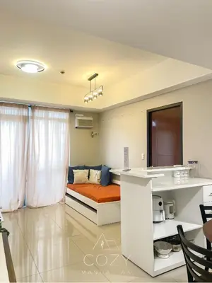 a room with a bed and a table and a kitchen at Cozy Manhattan Heights 1 Bedroom Araneta Cubao in Manila