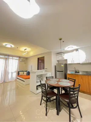 a kitchen and living room with a table and chairs at Cozy Manhattan Heights 1 Bedroom Araneta Cubao in Manila