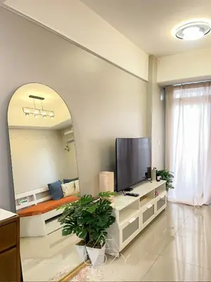 a living room with a tv and a large mirror at Cozy Manhattan Heights 1 Bedroom Araneta Cubao in Manila