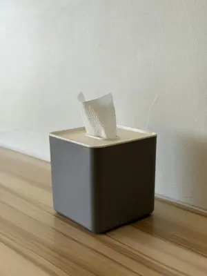 a box with a piece of paper sitting on a wooden floor at AlRBNB Mandaluyong - by Jam Es in Manila