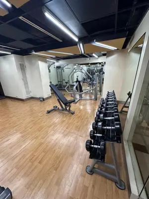 a gym with dumbbells and a row of treadles at Canal View Luxury Stay, Studio type , Massage Chair, Office Desk in Manila