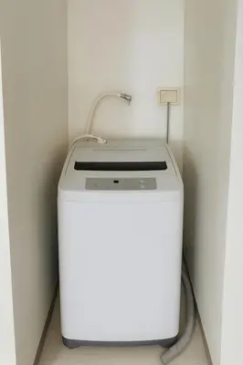 a white washing machine in a corner of a room at SMDC BREEZE Manila Bay Sunset View in Manila
