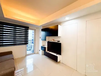 a living room with a flat screen tv in a room at R E Staycations in Manila