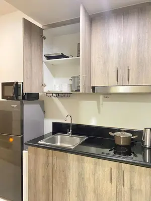 a kitchen with a sink and a refrigerator at 1BR Cozy Minimalist Unit near MOA or Manila Bay in Manila