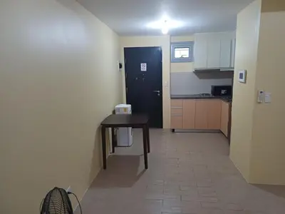 a small kitchen with a table and a black door at GambinoAirbnb in Manila