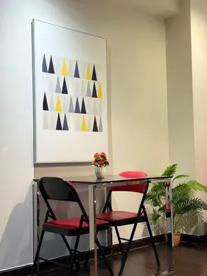 a dining room table with two chairs and a painting at The Gramercy Residences Executive 1 bedroom with Balcony in Manila