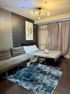 a living room with two beds and a couch at The Gramercy Residences Executive 1 bedroom with Balcony in Manila