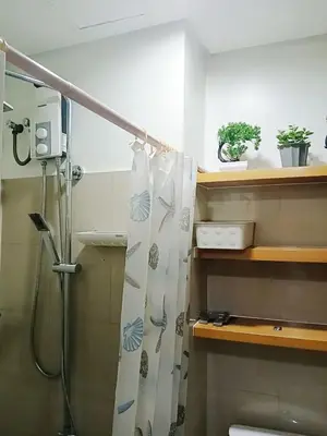 a bathroom with a shower with a shower curtain at Warm Retreat with Balcony at Shore 2 Residences in Manila